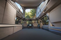 Image of the Volkswagen California interior with bed folded out and pop top raised