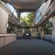 Image of the Volkswagen California interior with bed folded out and pop top raised