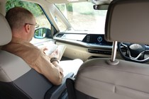 Image of a man reading in the front passenger seat of a campervan