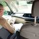 Image of a man reading in the front passenger seat of a campervan