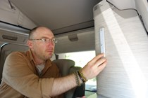 Image of a man installing a stick-on light in a camper van