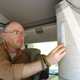 Image of a man installing a stick-on light in a camper van