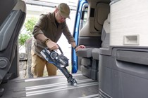 Image of a man vacuuming the floor of a campervan