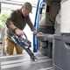 Image of a man vacuuming the floor of a campervan