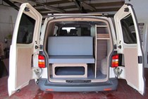Image of the living space in a Volkswagen Transporter DIY campervan conversion, viewed through the open rear doors