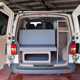 Image of the living space in a Volkswagen Transporter DIY campervan conversion, viewed through the open rear doors