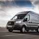 Image of a grey Ford Transit driving, viewed from the front left corner