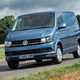Image of a blue Volkswagen Transporter driving round a corner, viewed from the front left corner