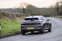 Image of a DS 4, in grey, driving round a right-hand corner, viewed from the car's rear right corner