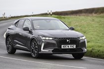 Image of a DS 4, in grey, driving round a right-hand corner, viewed from the car's front right corner