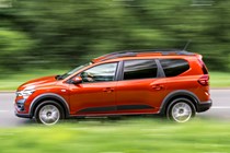 Dacia Jogger (2023) review: side view driving, country lane, orange paint