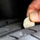 Image of a 20p coin inserted into a tyre's tread to check its depth