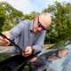 Image of a man checking the condition of a car's wiper blades