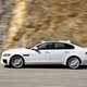 Image of a white Jaguar XF, viewed from the left side while driving