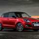 Suzuki Swift (2023) review: rear three quarter static, on the beach, red paint, at night