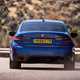 BMW 3 Series review - dead-on rear view, blue, driving round corner