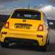 Abarth 595 (2022) review: rear three quarter driving, yellow car, wooded lane