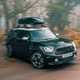 MINI Countryman (2023) review: front three quarter cornering, moving from gravel to tarmac road, black paint
