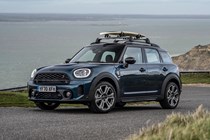 MINI Countryman (2023) review: front three quarter static, surfboard on roof, blue paint, sea in background