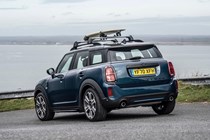 MINI Countryman (2023) review: rear three quarter static, surfboard on roof, blue paint, sea in background
