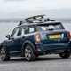 MINI Countryman (2023) review: rear three quarter static, surfboard on roof, blue paint, sea in background