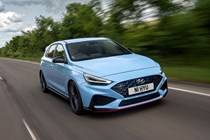 Hyundai i30 (2022) review - i30 N front action shot, rolling down leafy road, blue car