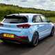 Hyundai i30 (2022) review - i30 N rear action shot, rolling down British B-road, blue car