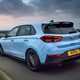 Hyundai i30 (2022) review - i30 N rear cornering shot, sunset skyline, lens flare, blue car