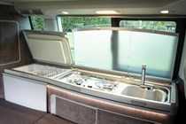 Interior shot of VW California's sink and fridge area.