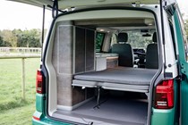 Interior shot of VW California, showing bed and integrated lockers from exterior rear of campervan