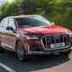 Audi SQ7 (2022) review - front three quarter driving tracking shot, red car, low shadow, leafy road