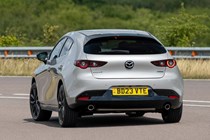 Mazda 3 (2023) review: rear three quarter cornering, silver paint, country lane