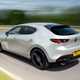 Mazda 3 (2023) review: rear three quarter cornering, long exposure, silver paint, country lane