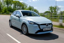 Mazda 2 (2023) review: front three quarter tracking cornering, blue paint, British country road