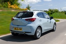 Mazda 2 (2023) review: rear three quarter driving, blue paint, British country road