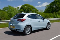Mazda 2 (2023) review: rear three quarter tracking cornering, blue paint, British country road