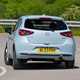 Mazda 2 (2023) review: rear three quarter cornering, showing body roll, blue paint, British country road