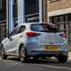 Mazda 2 (2023) review: rear three quarter static, blue paint, urban background
