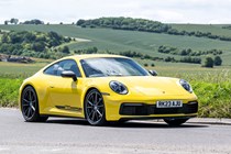 Porsche 911 review (992) - Carrera T, yellow, front side, driving round corner