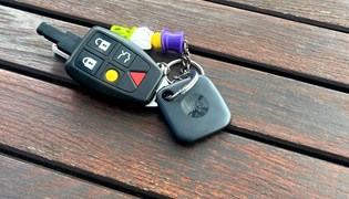 A Tile key finder attached to a car key