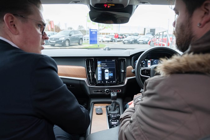 Keith WR Jones being shown how to operate the Volvo S90's multimedia system