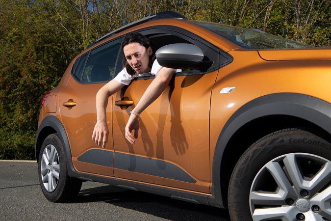 Dacia Sandero Stepway long-term: Luke Wilkinson looking rather ill, hanging out of the window, orange paint
