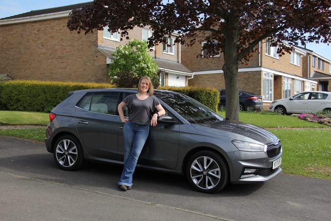 Cat Dow stands in front of a grey 2021 Skoda Fabia long-termer