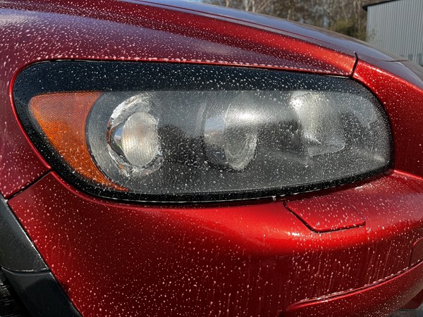 A headlight with pre-wash sprayed onto it