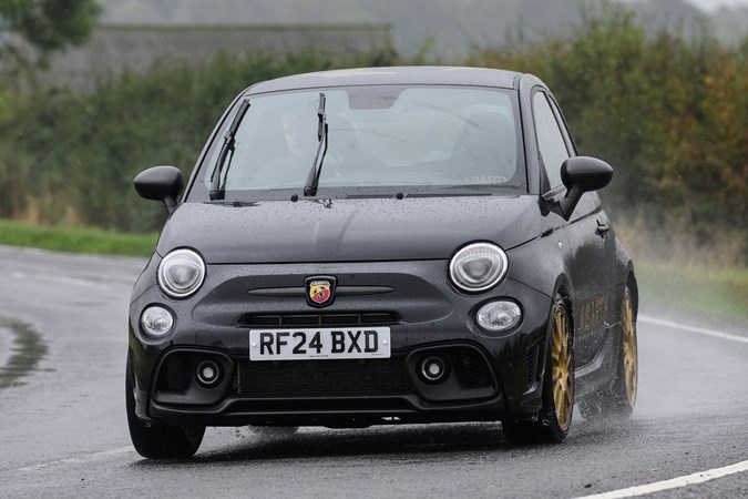 Abarth 695 (2024) review: front three quarter cornering, close up, rain, black paint