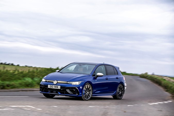 Image of blue Volkswagen Golf R, front left view, driving round corner