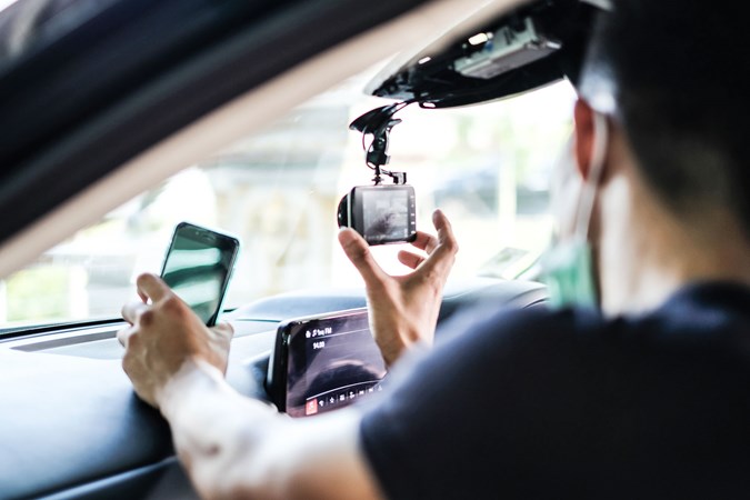 A dash cam being installed in a car.