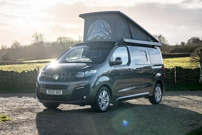 Vauxhall Vivaro Elite campervan parked in a park with sunset light and the roof popped
