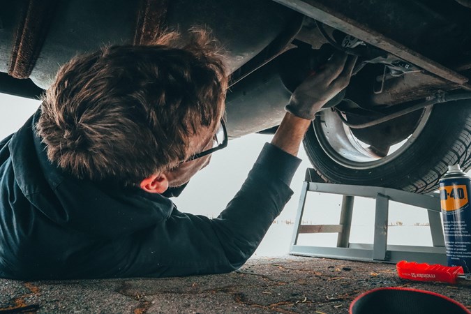 Mechanic working on the underside of a car
