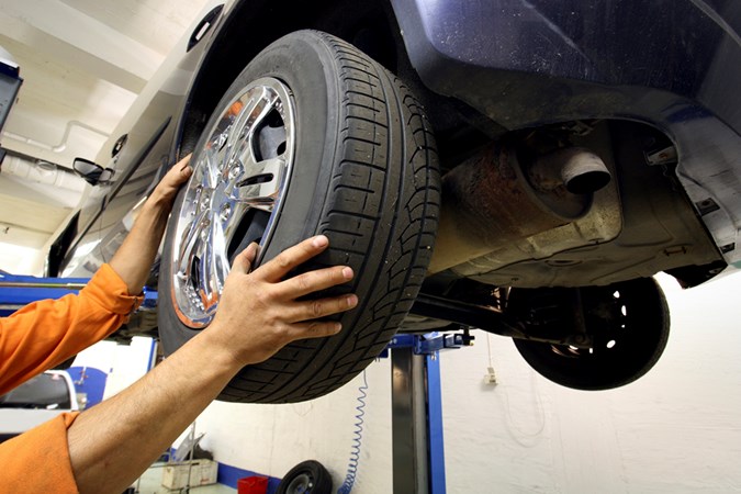 Used car paperwork: Checking a wheel for tyre condition and play is part of the MoT